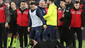 Galatasaray coach Okan Buruk (bottom) lies on the ground after Fenerbahce manager Jose Mourinho (centre) grabbed his nose at