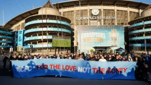 Manchester City fans hold a banner in protest of ticket reselling (Martin Rickett/PA)