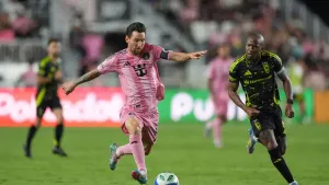 Inter Miami forward Lionel Messi (10) drives down field chased by Columbus Crew midfielder Darlington Nagbe (6) during the s